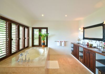 The bathroom showing the bath and twin basins, with the shower room with WC, bidet and shower beyond. A large dressing room with cupboards and a sofa is through a sliding door to the right, but also accessible directly from the bedroom.